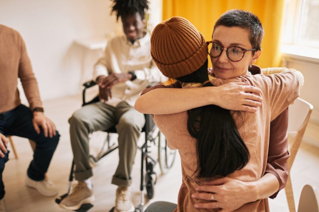 women-hugging-group-therapy